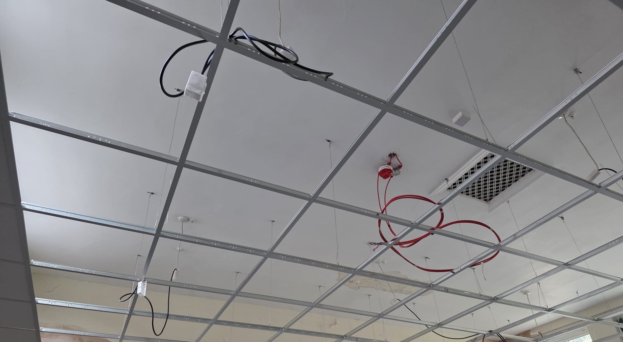 A suspended ceiling grid fitted level across a large room, before the tiles go in